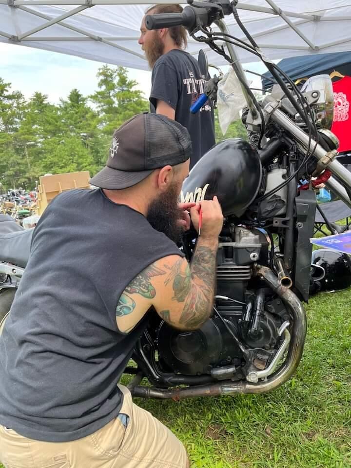 Veteran wrenching on a bike at an event