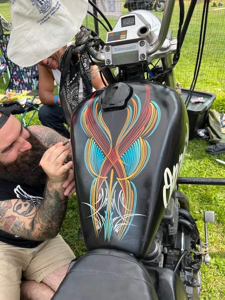 Hand-painted pinstriping on a custom motorcycle tank
